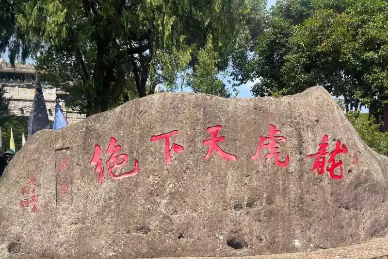 Ancient stone monument at Longhushan Mountain (Dragon Tiger Mountain) entrance displaying red Chinese characters, the birthplace of Taoist Feng Shui traditions in China