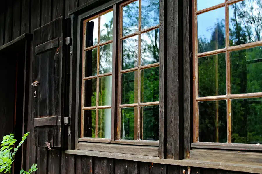 Can mirrors face windows in feng shui - rustic cabin window reflecting in framed mirror with natural light and energy circulation