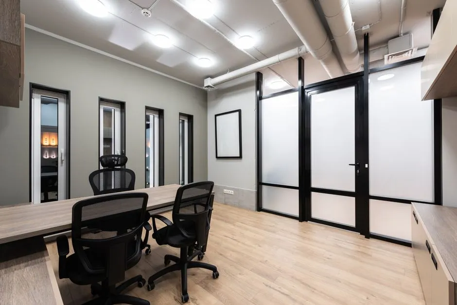 Feng shui office layout with wooden furniture, black chairs, and spacious room arrangement promoting smooth qi flow throughout the workspace